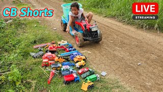 Yana rides a tractor looking for small cars on the road near the potato field